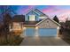 Charming two-story home featuring a stone and blue facade, three-car garage, and landscaped front yard at 5604 S Shawnee St, Aurora, CO 80015