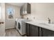 Functional laundry room with modern washer, dryer, cabinets, and sink at 5604 S Shawnee St, Aurora, CO 80015