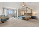 Spacious main bedroom featuring a four-poster bed, sitting area, a ceiling fan, and large windows at 5604 S Shawnee St, Aurora, CO 80015