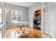 Well-lit home office featuring hardwood floors, a white desk, and built-in shelves at 5604 S Shawnee St, Aurora, CO 80015