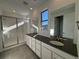 Modern bathroom with double vanity, dark countertop, and glass shower at 3104 S Russell St, Morrison, CO 80465