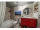 Modern bathroom featuring a striking red vanity, stylish mirror, tiled shower, and updated fixtures at 7356 S Miller Ct, Littleton, CO 80127