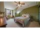 Comfortable bedroom featuring sloped ceilings, a ceiling fan, and a large window for natural light at 7356 S Miller Ct, Littleton, CO 80127