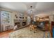 Inviting living room with brick fireplace, hardwood floors, and an open layout to the kitchen at 7356 S Miller Ct, Littleton, CO 80127