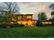 Lush backyard features a spacious lawn, mature trees, and a modern home with expansive windows at 700 Utica Ave, Boulder, CO 80304