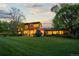 Spacious backyard featuring lush lawn, mature trees, and a modern home with large windows and ample light at 700 Utica Ave, Boulder, CO 80304