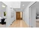 Light filled hallway with wood floors featuring a custom front door and access to other rooms at 700 Utica Ave, Boulder, CO 80304