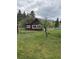 Spacious backyard with green grass, mature trees, and a cozy single-story house at 245 Lower Glenway St, Palmer Lake, CO 80133