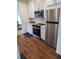 Modern kitchen featuring stainless steel appliances, white cabinetry, and wood-look flooring at 245 Lower Glenway St, Palmer Lake, CO 80133
