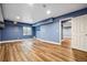 Finished basement featuring wood-look floors, blue accent wall, and an open layout at 5395 S Flanders Way, Centennial, CO 80015