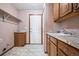 Laundry room featuring wood cabinets, granite counters, tile floors and a utility sink at 5395 S Flanders Way, Centennial, CO 80015