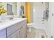 Bright bathroom featuring a single sink vanity, yellow shower curtain, and neutral color scheme at 834 N Bently St, Watkins, CO 80137