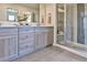Modern bathroom with double sink vanity, gray wood cabinets, and glass-enclosed shower at 834 N Bently St, Watkins, CO 80137