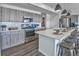 Kitchen with stainless steel appliances, wooden cabinets, subway tile backsplash, and an island with bar seating at 834 N Bently St, Watkins, CO 80137