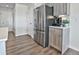 View of stainless steel fridge, wood cabinet, and hardwood flooring in a bright kitchen at 834 N Bently St, Watkins, CO 80137