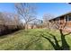 Backyard with mature tree, full lawn, flower bed and view of neighboring house at 13648 W 66Th Way, Arvada, CO 80004