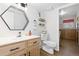 Well-lit bathroom with modern fixtures, wood vanity, framed mirror, and access to the laundry room at 13648 W 66Th Way, Arvada, CO 80004