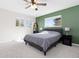 Tranquil bedroom with a comfortable bed, green accent wall, and abundant natural light from multiple windows at 13648 W 66Th Way, Arvada, CO 80004