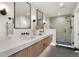 Modern bathroom featuring double vanity, sleek mirrors, and a glass-enclosed shower at 2230 W 36Th Ave, Denver, CO 80211