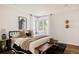 Stylishly furnished bedroom featuring hardwood floors and a comfortable bed near a bright bay window at 1185 S Steele St, Denver, CO 80210