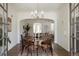 Bright dining room boasts hardwood floors, large table, chandelier, and flows into the living room for open concept living at 1185 S Steele St, Denver, CO 80210