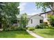 Charming single story home with white painted brick, manicured lawn, landscaping, and mature trees in a desirable neighborhood at 1185 S Steele St, Denver, CO 80210