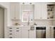 Bright kitchen featuring white cabinets, stainless steel appliances, stylish fixtures, and natural light at 1185 S Steele St, Denver, CO 80210
