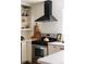 Kitchen detail showcasing stainless steel range, modern hood, open shelving, and ample counter space at 1185 S Steele St, Denver, CO 80210