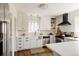 Modern kitchen with white cabinets, stainless steel appliances, a black range hood, and light countertops at 1185 S Steele St, Denver, CO 80210