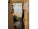 Bathroom with shower behind curtain, dark cabinets and granite countertop at 4449 S Xavier St, Denver, CO 80236