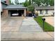 Long concrete driveway leading to an attached garage of brick home at 4449 S Xavier St, Denver, CO 80236