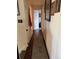 Hallway view with wood floors, neutral paint, and decoratively framed pictures, and a view to another room at 4449 S Xavier St, Denver, CO 80236