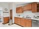 A bright kitchen shows wood cabinetry, stainless steel appliances, double basin sink, and white countertops at 701 S Roosevelt Ave, Lafayette, CO 80026