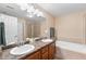 Bathroom featuring a double vanity, bathtub and shower with glass enclosure at 8779 S Kipling Way # 204, Littleton, CO 80127