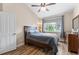 Bright bedroom boasts a ceiling fan, light wood flooring and a window with a view at 8779 S Kipling Way # 204, Littleton, CO 80127