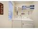 Functional laundry room with washer and dryer units, and shelving for storage at 2303 Monte Vista St, Fort Lupton, CO 80621