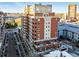 Stunning aerial view of a brick condo building featuring private patios and a beautiful city backdrop at 1950 N Logan St # 1109, Denver, CO 80203