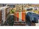 An aerial view showcasing a red brick building surrounded by cityscape and the building's rooftop terraces at 1950 N Logan St # 1109, Denver, CO 80203