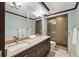 Modern bathroom with double sink vanity, granite countertop, and a glass-enclosed shower at 1950 N Logan St # 1109, Denver, CO 80203