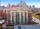 Multi-story building with cream and red brick exterior and multiple decks offers urban living at 1950 N Logan St # 1109, Denver, CO 80203
