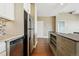 Kitchen with stainless steel appliances and wood floors leads to an open concept living area at 1950 N Logan St # 1109, Denver, CO 80203