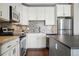 Well-equipped kitchen features stainless steel appliances, white cabinetry, and mosaic backsplash at 1950 N Logan St # 1109, Denver, CO 80203