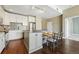 A well-lit kitchen featuring white cabinets, stainless steel appliances, a mosaic backsplash, and a kitchen island at 1950 N Logan St # 1109, Denver, CO 80203