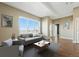 Bright living room boasts a large window with city views, hardwood floors, and modern decor at 1950 N Logan St # 1109, Denver, CO 80203