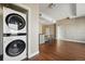 Washer and dryer located next to a spacious open-concept living space with beautiful wood floors at 1950 N Logan St # 1109, Denver, CO 80203