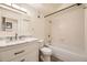 Bright bathroom featuring a marble vanity, tub with shower, and neutral tile flooring at 5995 W Hampden Ave # 8C, Denver, CO 80227