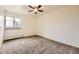 A cozy bedroom space features neutral carpeting, bright windows, and a ceiling fan for comfort at 5995 W Hampden Ave # 8C, Denver, CO 80227