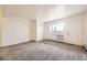 An empty bedroom features soft carpet, a closet, and a window for natural light, creating a calming space at 5995 W Hampden Ave # 8C, Denver, CO 80227