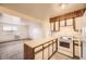 Open kitchen with wood accents, white appliances, and ample counter space flowing into the living area at 5995 W Hampden Ave # 8C, Denver, CO 80227