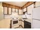 A functional kitchen features white appliances, wooden cabinets, and laminate countertops for a practical cooking space at 5995 W Hampden Ave # 8C, Denver, CO 80227